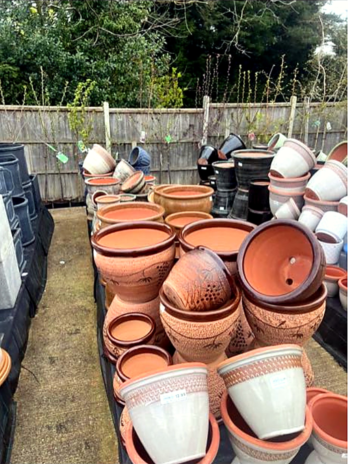 Decorated stone-effect pots with textured patterns stacked outdoors