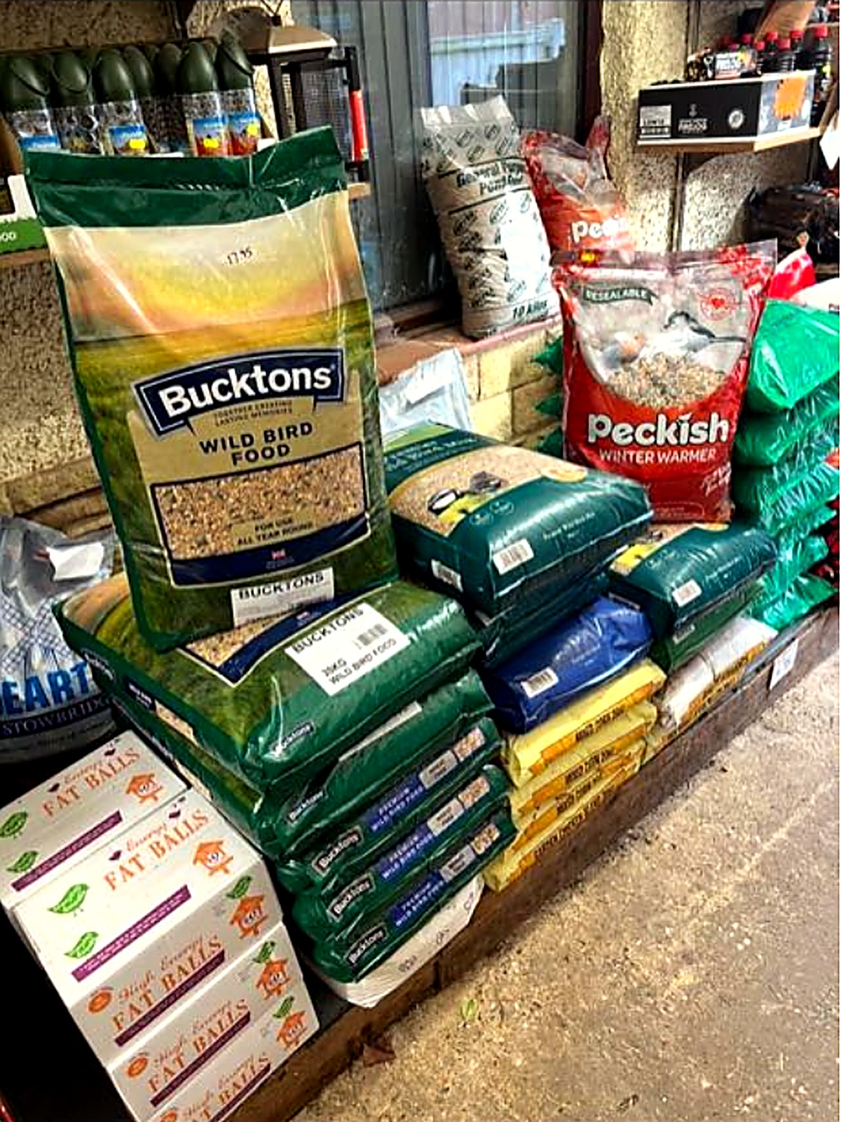 Sacks of Bucktons wild bird food and Peckish feed stacked in store