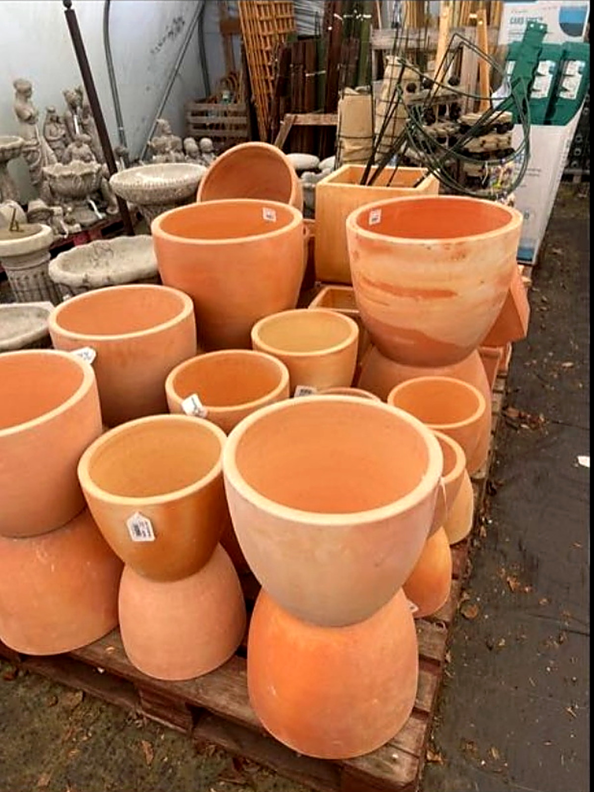 Large planters with stone bird baths and garden ornaments behind